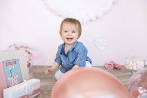 Photo d'une jolie petite fille dans un décor anniversaire rose